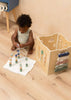 A young child plays with a bead maze and the Wooden Activity Cube, building fine motor skills. The engaging elements of the activity cube make it an ideal toy for toddlers in a cozy indoor setting.
