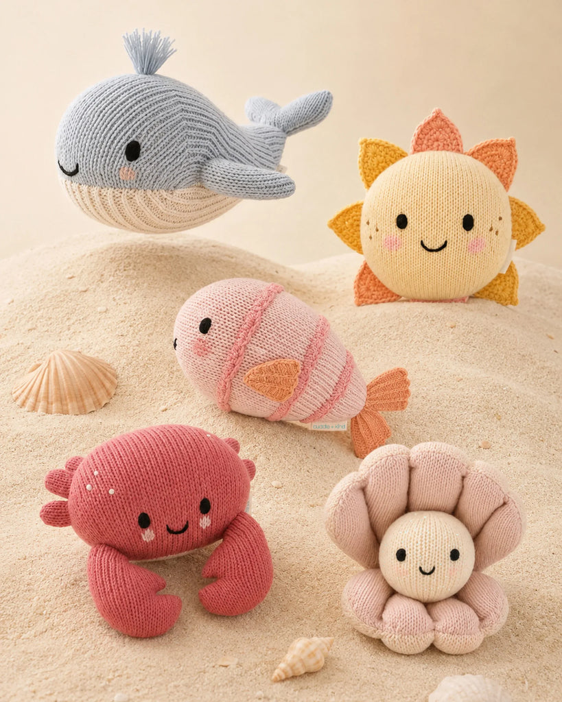 The Cuddle + Kind Baby Fish is a hand-knit, pastel-colored stuffed animal with a smiling face—a perfect heirloom-quality gift for little ones.