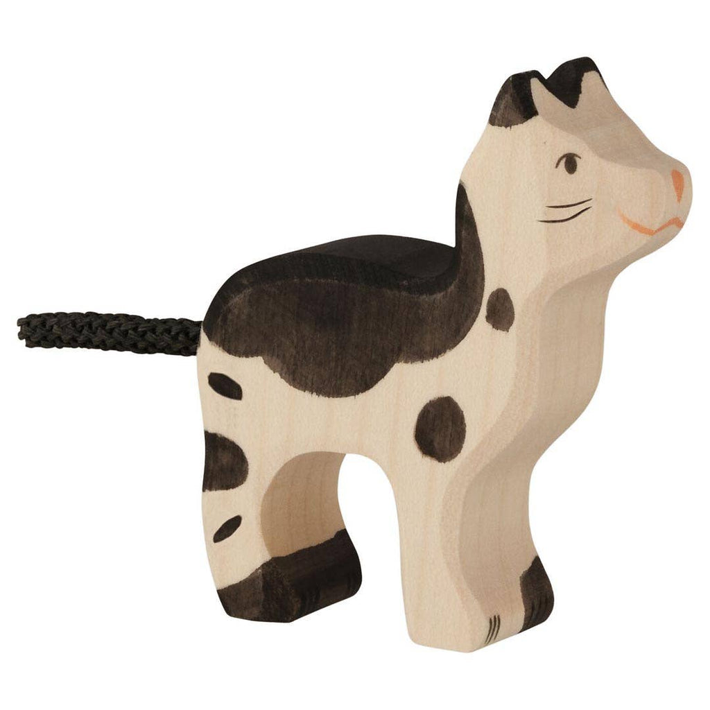 The Holztiger Cat, Ragdoll is a handcrafted wooden toy with black and brown spots, a smiling face, and a braided black tail. Made in Europe, it stands on all four legs and is part of the HOLZTIGER figures collection.