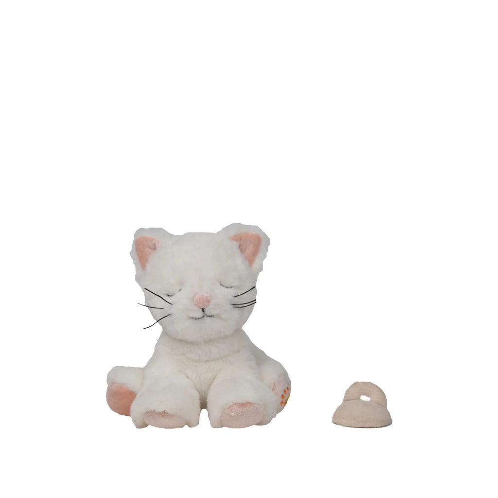 The Olli Ella Binky Kitten Kiki - White, a plush toy with closed eyes and pink accents, sits beside a small light beige slipper on a plain white background.