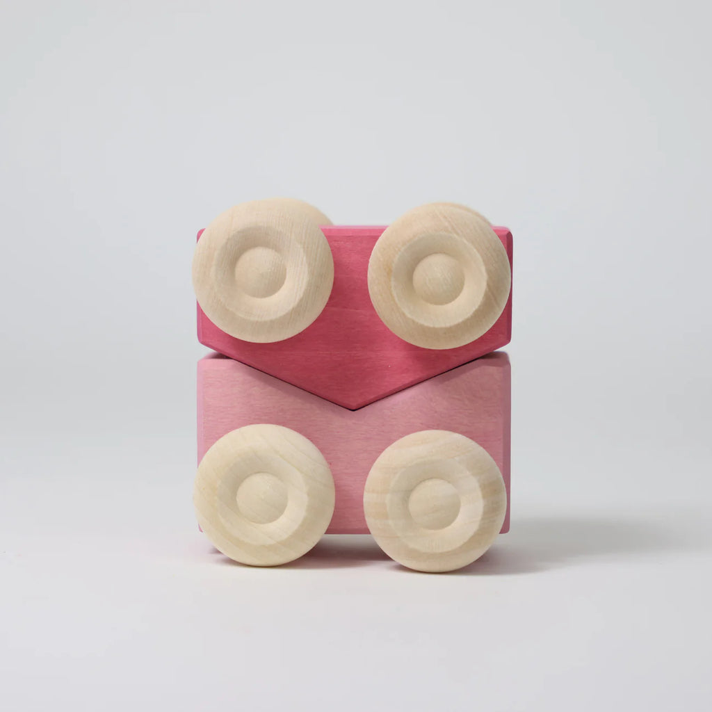 The Grimm's Stacking Cars - Pink features two pink wooden cars stacked vertically, each with two round, light wooden wheels, displayed against a plain white background.