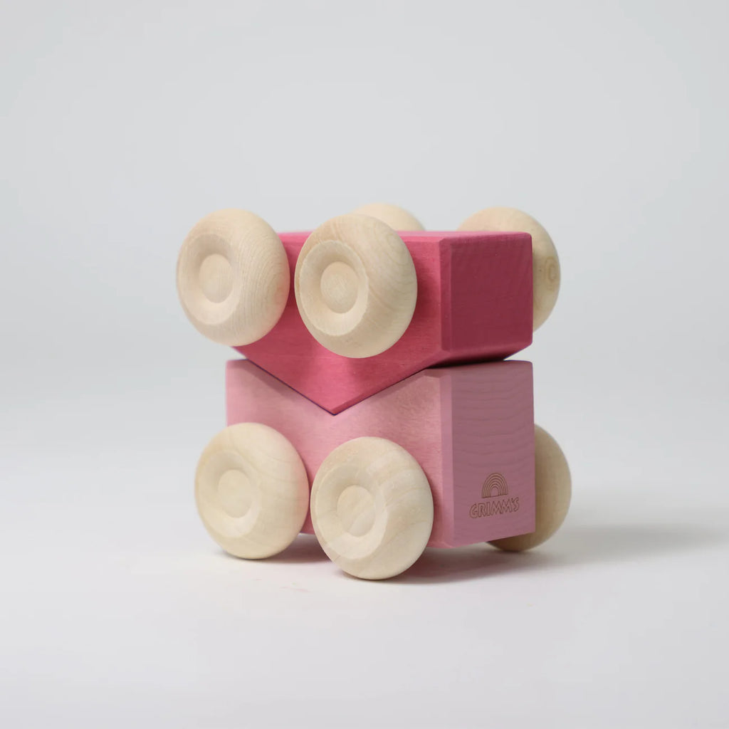 Grimm's Stacking Cars - Pink: A wooden toy car crafted from pink and magenta rectangular blocks with six light wheels, arranged in a geometric design—ideal for fans of color matching toys—shown on a plain white background.