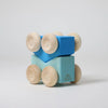 Grimm's Stacking Cars - Blue features two blue geometric blocks with four natural wood wheels, creating a playful abstract vehicle—ideal for stacking toy enthusiasts—displayed on a plain white background.