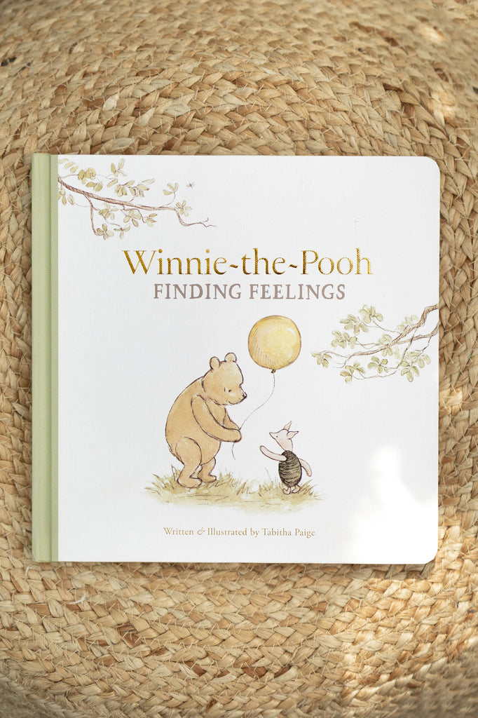 Winnie-the-Pooh: Finding Feelings is a board book by Tabitha Paige that helps toddlers explore emotions, featuring Pooh with a balloon and Piglet on a woven straw background.