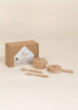 The Wooden Pots and Pans Playset (6 Pcs) features two wooden pots with lids, a spatula, and a spoon—ideal for inspiring imaginative play and creativity in little chefs. This kids kitchen playset is attractively displayed in front of a brown cardboard box with a white label.
