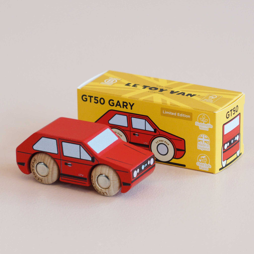 A small red wooden toy car sits beside a yellow box labeled “No. 8 GT50 Gary | Made in England,” featuring an illustration of the same car. The box displays “Limited Edition” along with eco-friendly icons, underscoring the vintage charm and retro cool appeal of this wooden car collectible.