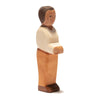 A handcrafted wooden figurine features a person with short black hair, a cream-colored long-sleeved shirt, and brown pants. The figure stands upright with its arms partially extended forward. Perfect for imaginative play, this minimalist design is reminiscent of Ostheimer Father, Cream Sweater.