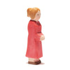 An Ostheimer Mother, Red Dress, figurine of a woman with blonde hair tied in a bun, wearing a long red dress, stands in profile. Crafted from sustainably sourced materials, the figure has minimal facial features and simplified details, embodying the essence of handcrafted wooden toys.