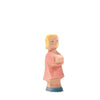 The Ostheimer Daughter in Pink Dress is a small wooden figurine of a person with short blond hair, painted with a pink outfit and blue shoes. The figurine, resembling the iconic style of Ostheimer toys, has a simple design and carved features, standing upright against a plain white background.