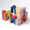An abstract structure made with Grimm's Panorama Building Set—colorful wooden arches, rectangles, squares, and curved blocks—from the Tiny Art Collection stands on a plain white background.