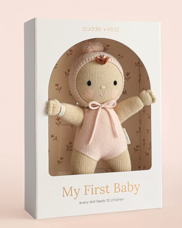 The Cuddle + Kind My First Baby (Blush), hand-knit from natural cotton yarn and dressed in pink, comes in a white box and provides 10 meals to children with every purchase. Ships in one week.