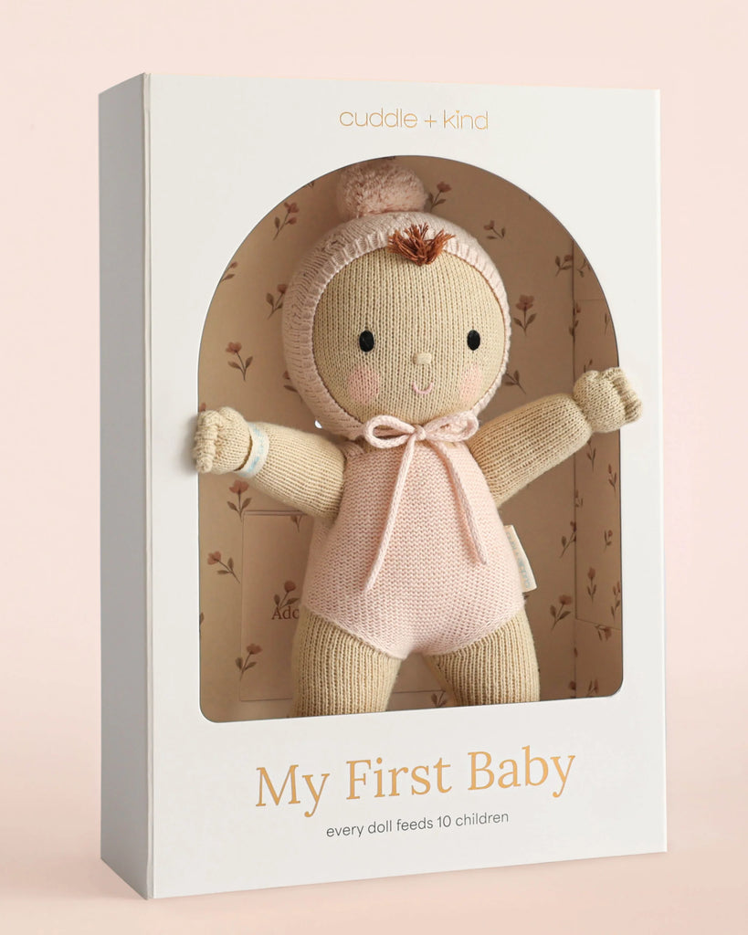 The Cuddle + Kind My First Baby (Blush), hand-knit from natural cotton yarn and dressed in pink, comes in a white box and provides 10 meals to children with every purchase. Ships in one week.