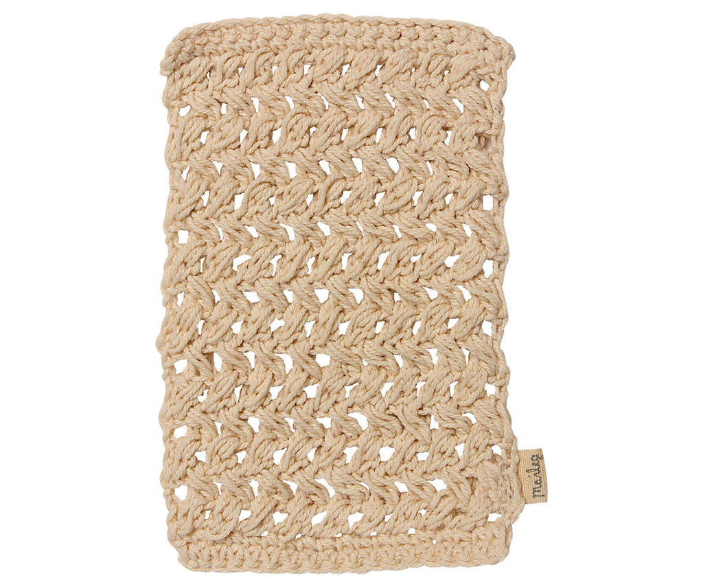 A rectangular, beige, hand-knitted washcloth made of thick, textured yarn with a small branded tag—perfect for use with your Maileg Bathroom Set or as part of your Maileg Wellness Accessories.
