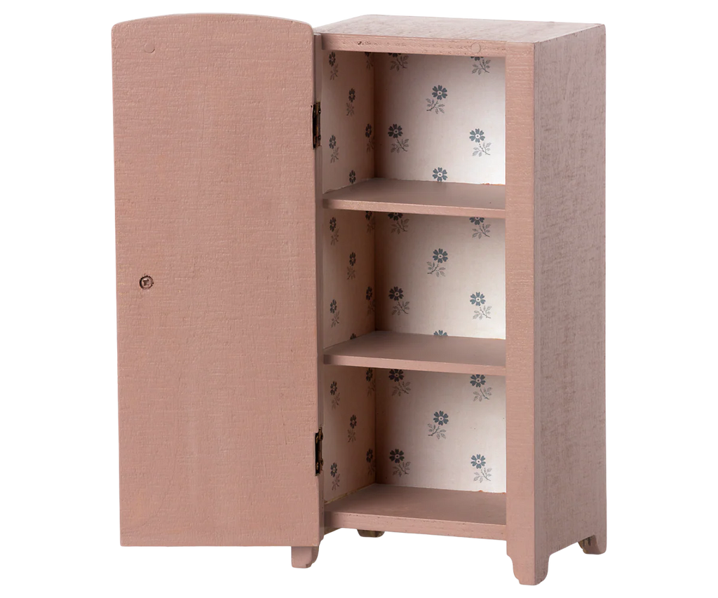 The Maileg Miniature Closet is a small vintage-style piece made from FSC wood, featuring one open door with three organizing shelves lined in blue floral wallpaper and a light pinkish-brown painted exterior.