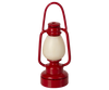 The Maileg Gingerbread House Christmas Set features a red lantern-shaped design with a cream central section, handle, and rounded base, isolated on a white background.