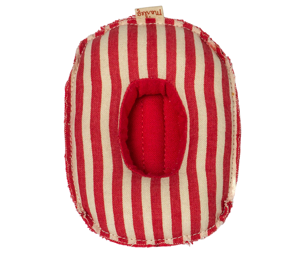 The Maileg Rubber Boat, Small Mouse - Red Stripe is a soft, oval-shaped toy with red and beige stripes and a central red opening, frayed edges, and a fabric tag—perfect as an accessory for Maileg mice.