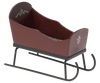 A small, decorative Maileg Christmas Sleigh - Red with a red body and ornate hand-painted details on the sides. The sleigh has black metal runners and curved front rails, ensuring it’s both stylish and functional.