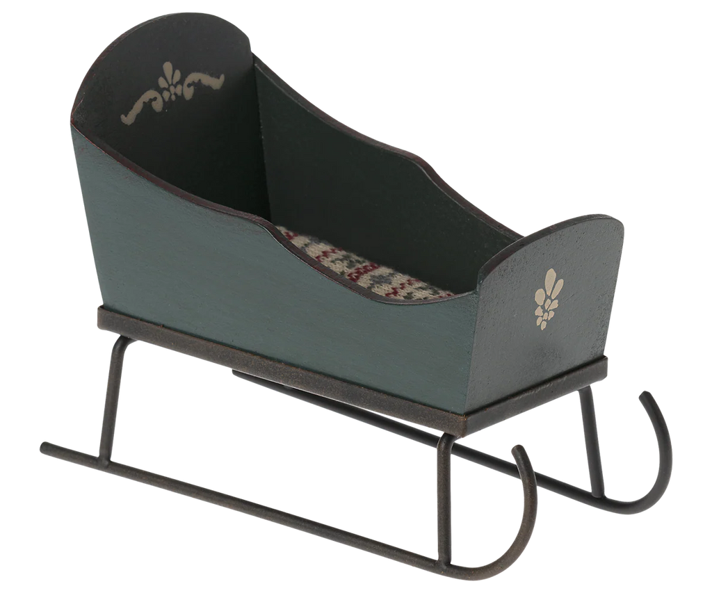 The Maileg Sleigh, Mouse - Green is a small decorative wooden sleigh with white painted designs, a patterned fabric seat, and curved metal runners—ideal as dollhouse furniture or for miniature mice accessories.