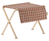 The Maileg Nursery Table, Micro - Red Checker is shown with a small folding stool featuring beige metal legs and a red and white checkered seat, perfect for nurseries. Set against a white background.