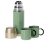 The Maileg LouiMax Little Explorer Set features a green thermos with a metallic lid, two matching mugs, a gold-colored cup, and a miniature lantern, all displayed on a plain white background.