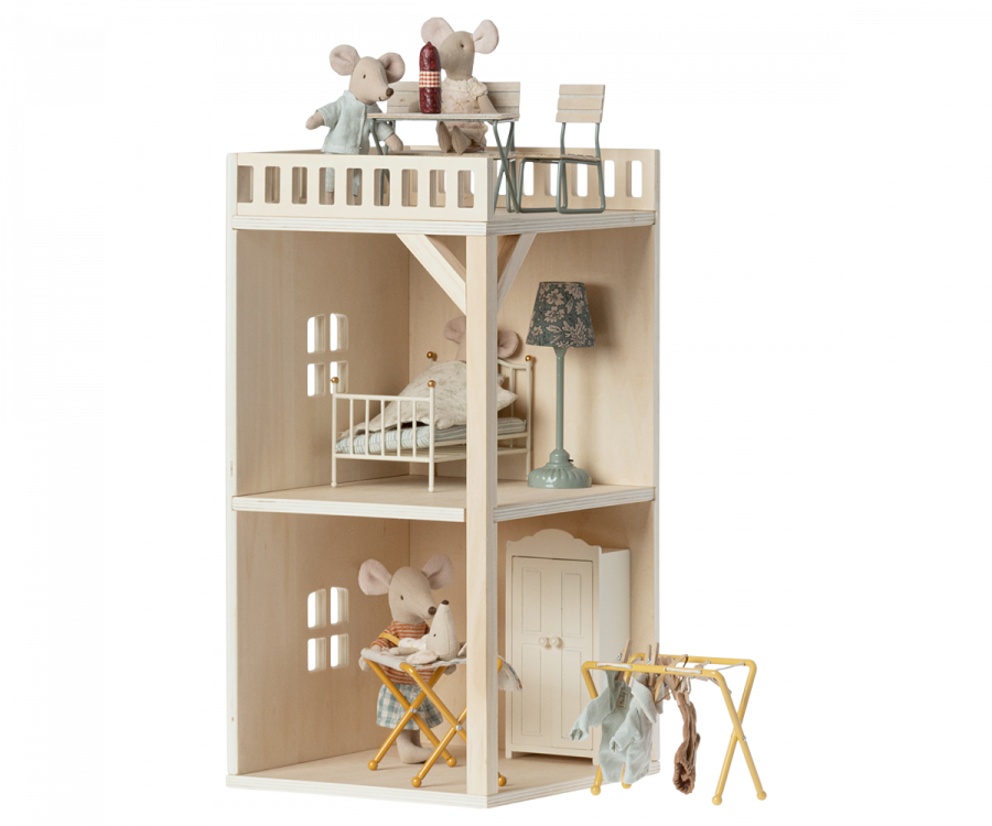 A Maileg Farmhouse - Annex Bonus Room wooden dollhouse with two levels and an open design, featuring miniature furniture and mouse figures engaged in domestic activities.