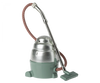 Vintage green and silver Maileg Miniature Vacuum Cleaner with a long hose and a fabric-covered cord, isolated on a grey background.