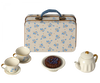 A vintage floral metal suitcase with a Maileg Miniature Afternoon Treat Tea Set - Blue Madelaine, depicting a quaint tea setting.