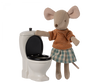 White mini toilet with black toilet. Fabric mouse with striped orange shirt and blue and white skirt. 