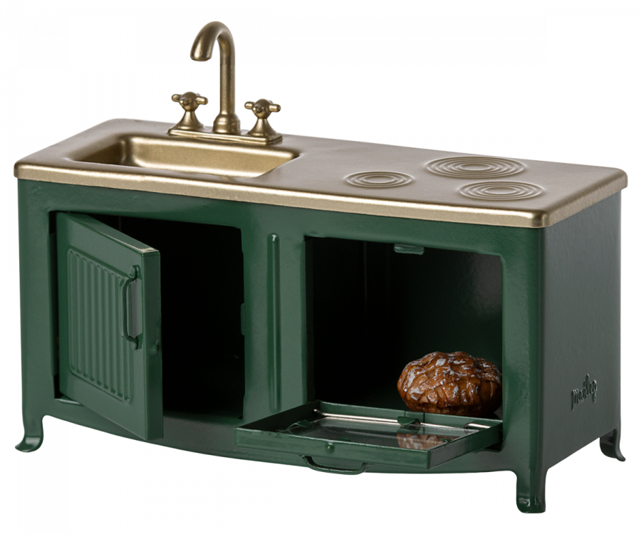 A Maileg Kitchen - Dark Green with a metallic gold sink and faucet, oven with an open drawer revealing freshly baked pie, and a stovetop.