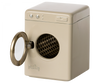 A small, vintage-inspired, cream-colored Maileg Washing Machine For Mice with a transparent circular door on the front and a black, honeycomb-patterned interior.