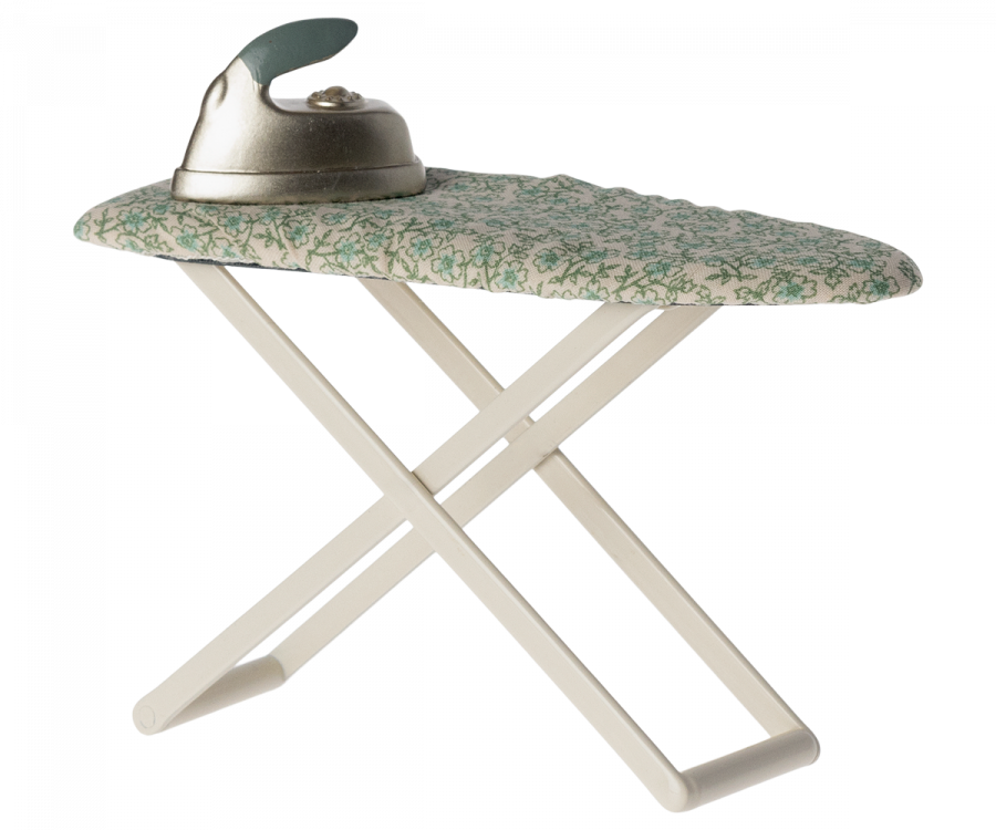An iron resting on an open iron board with a Maileg Ironing - Mouse Size fabric cover featuring a mouse family design, isolated against a black background.