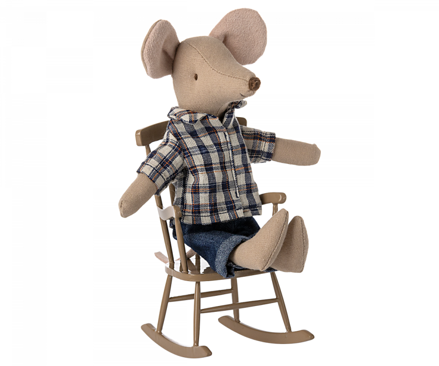 A small, light brown Maileg Rocking Chair, Mouse - Light brown sits in a miniature wooden rocking chair. The mouse, part of a charming mouse family, is dressed in a blue and white plaid shirt and blue jeans, with its legs stretched out and arms resting on the chair's arms.
