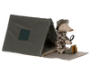A Maileg mouse wearing a plaid shirt and detective hat, holding a magnifying glass, is near a Maileg Single Tent, Mouse Size on a textured surface, suggesting an adventure or investigation theme.