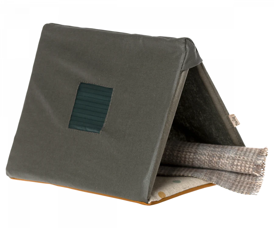 Three stacked fabric swatches in varying textures and colors, displayed angled with the topmost swatch in olive green featuring a small, rectangular, Maileg Single Tent, Mouse Size panel.