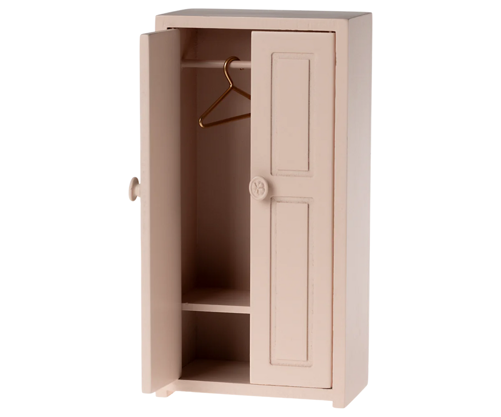 A light rose Maileg Mouse Closet with one door slightly open, displaying a solitary golden hanger. This closet is enhanced with a decorative knob and includes two compartments at the bottom, making it an ideal choice for a mice family’s wardrobe or as an enchanting children's toy.