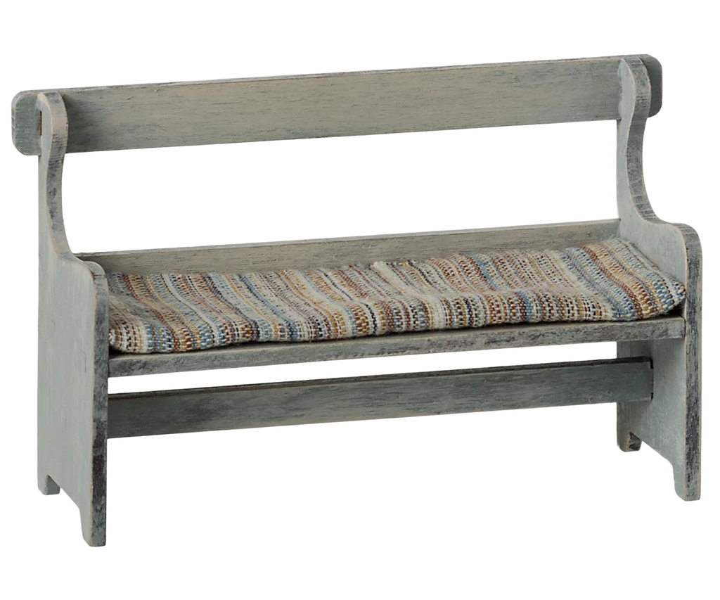 The Maileg Mouse Bench - Off-White features a vintage wooden design with a high back and armrests, adorned with a colorful striped, hand-painted seat cushion. Its comfortable seat and rustic worn finish enhance its antique charm.