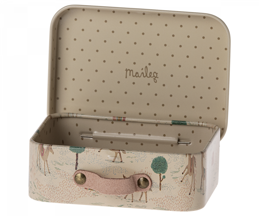 Introducing the Maileg Suitcase, Micro: a charming small metal suitcase featuring a beige polka dot interior. Its exterior boasts colorful illustrations of a whimsical forest scene with trees and deer. The pink handle is secured with brass buttons, adding to its delightful design. Ideal for storing small items, the back panel inside proudly displays the word "Maileg.