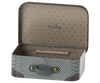 The Maileg Suitcase, Micro is a small metal suitcase featuring a blue and beige polka dot interior and a blue wavy pattern exterior. Ideal for storing small items, it comes with a grey handle accented by brass buttons and has the word "Maileg" printed on the inside of the lid.