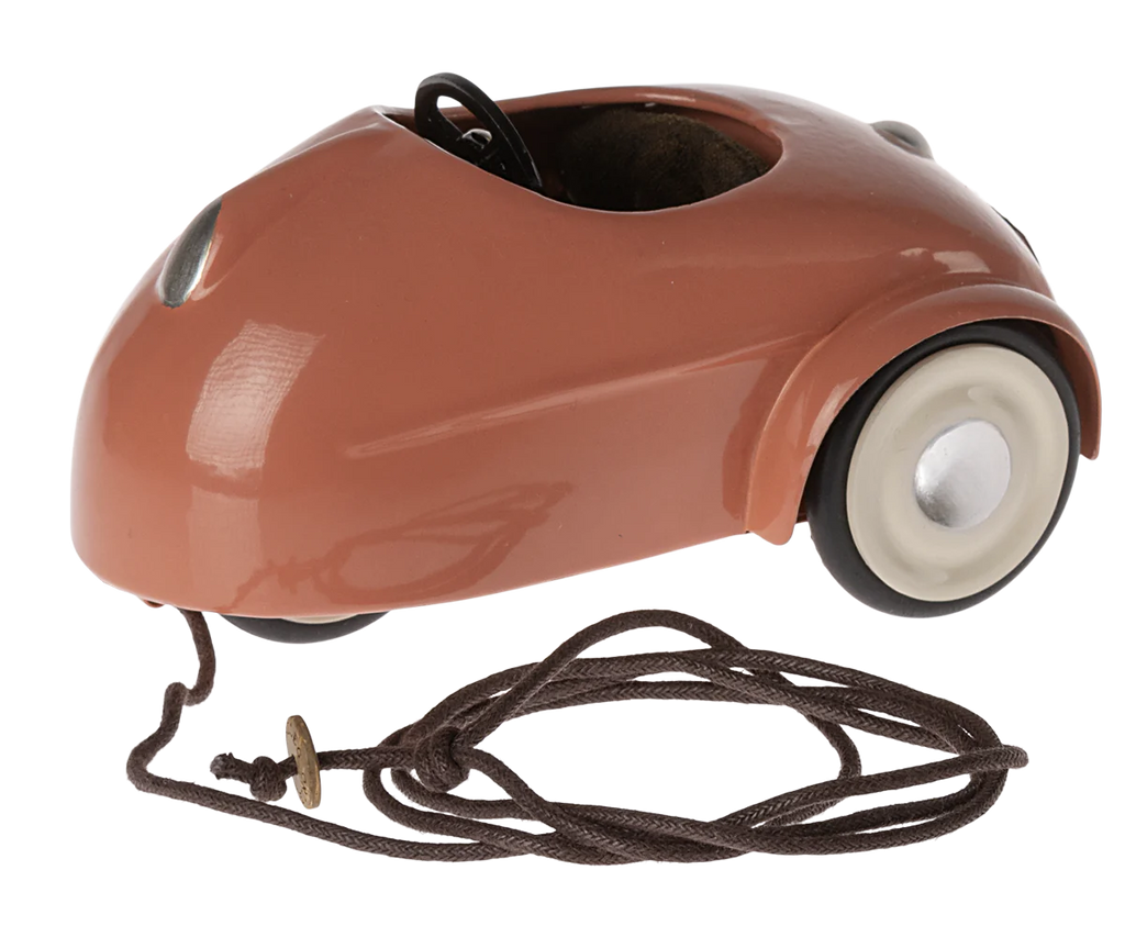 Maileg Mouse Car - Coral in a shiny copper color with a visible seat and steering wheel, and a brown power cord attached to the side.