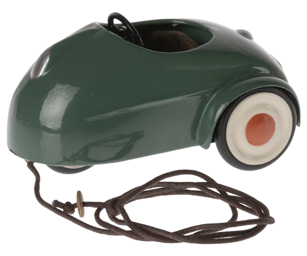 The Maileg Big Brother and Sister Adventure Set includes a small, green, vintage-style mouse car with white wheels, a brown pull string at the front, and an open top—perfect for Maileg big sister or brother mice.