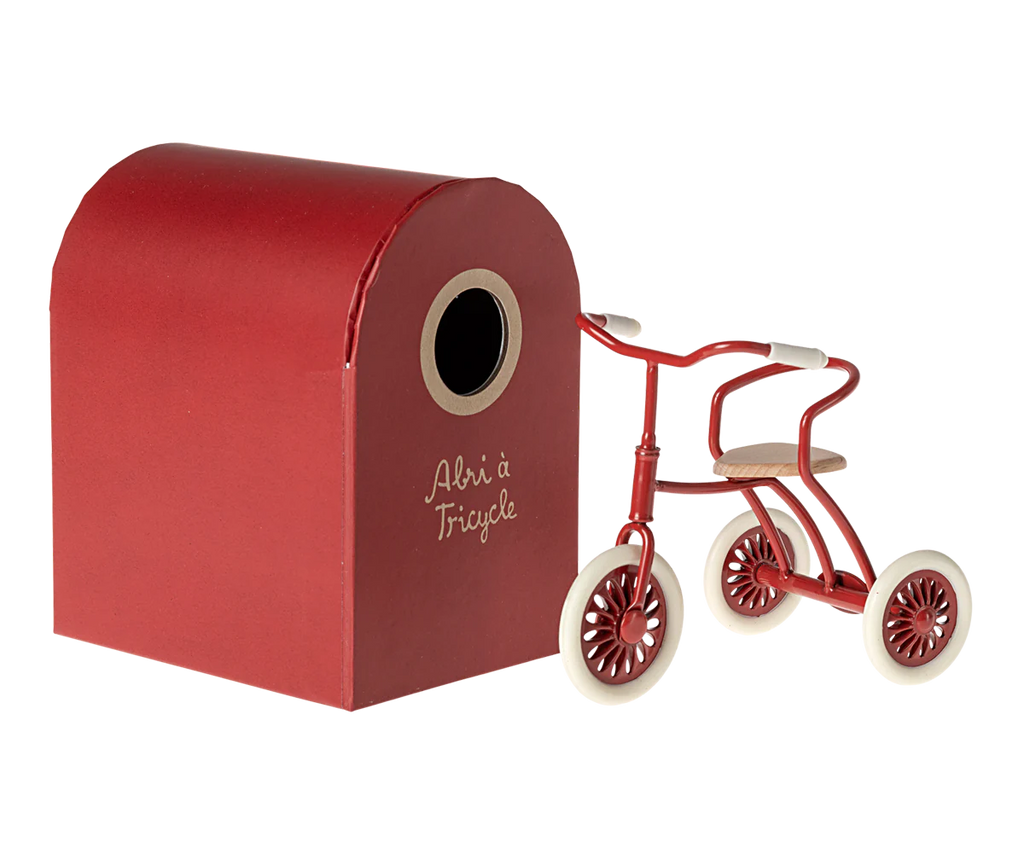 Miniature red tricycle toy. 