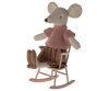 A stuffed toy mouse dressed in a knitted pink top and a striped skirt sits in a Maileg Rocking Chair, Mouse - Dark Powder. The mouse has large beige ears and a pointed snout, with small legs and feet. The scene is whimsical and charming, showcasing delightful mouse accessories.