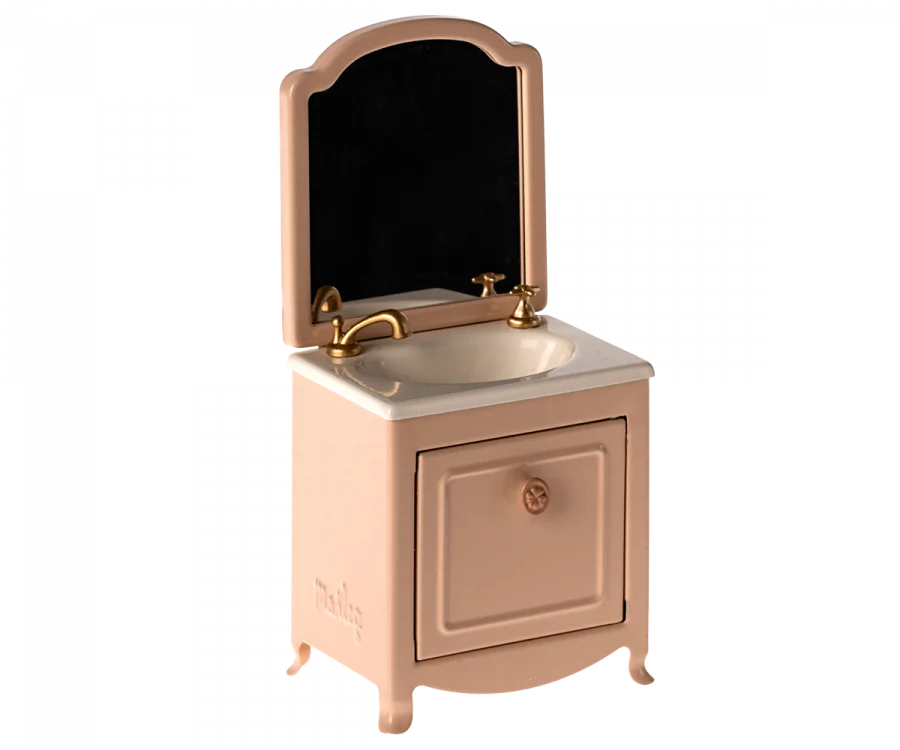 The Maileg Bathroom Set features a pink vanity with gold faucet, white sink, mirror, and cabinet—ideal for creating a charming spa scene in your dollhouse when paired with Maileg Wellness Accessories.
