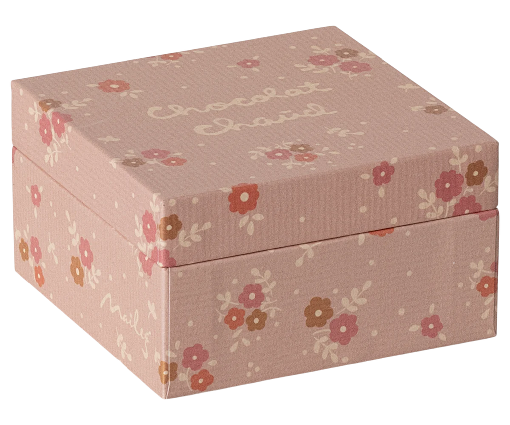 A small, square pink gift box decorated with a floral pattern and polka dots, featuring "Chocolat Chatel" in a white handwritten-style font on the lid. Inside awaits the Maileg Hot Chocolate Set, Mini—ideal for crafting the perfect hot chocolate experience.