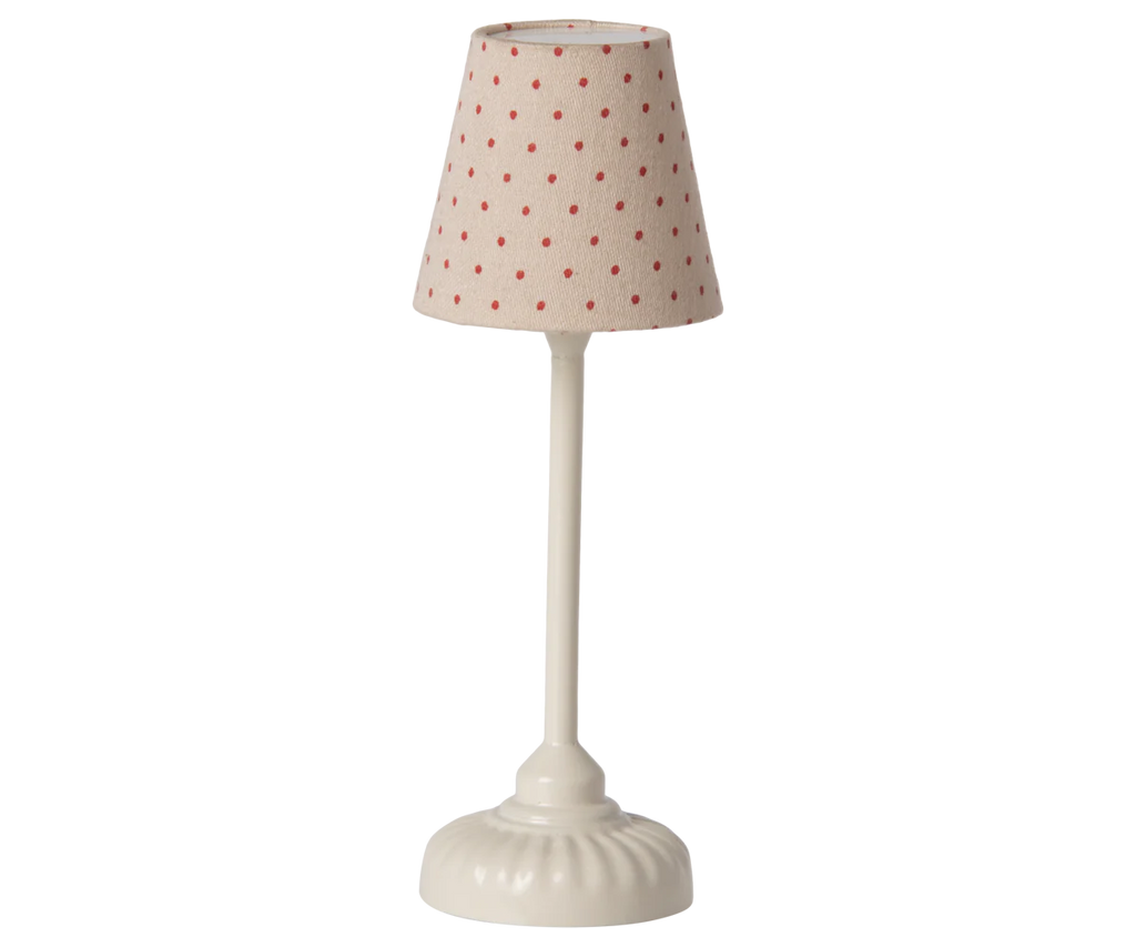 The compact table lamp features a white base and a fabric shade decorated with red polka dots against a beige background. Its vintage, minimalist design echoes the charm and simplicity of the Maileg Mouse Size Vintage Floor Lamp - Sand (With Battery) collection.