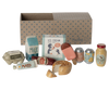 A delightful Maileg Miniature Grocery Box is displayed in front of a cardboard box with blue polka dots. Visible items include milk, ice cream, a popsicle, cans of sparkling water, a honey jar, a baguette, cheese, mayonnaise, an egg carton, and a jar of jam—perfect for any Maileg friend food collection.