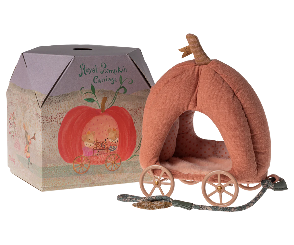 A plush pumpkin carriage toy sits next to its cardboard packaging. The packaging reads "Maileg Pumpkin Carriage" and features an illustration of a fairytale carriage. The plush toy has a pink exterior, polka-dot interior, and golden wheels—truly the perfect carriage for any royal mice family.