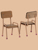 Two Maileg School Table & Chair Sets for Mice in Dark Powder are showcased against a beige background. One chair faces forward, and the other displays its backrest, highlighting their elegant design with beech wood, metal frames, and pink rubber feet.