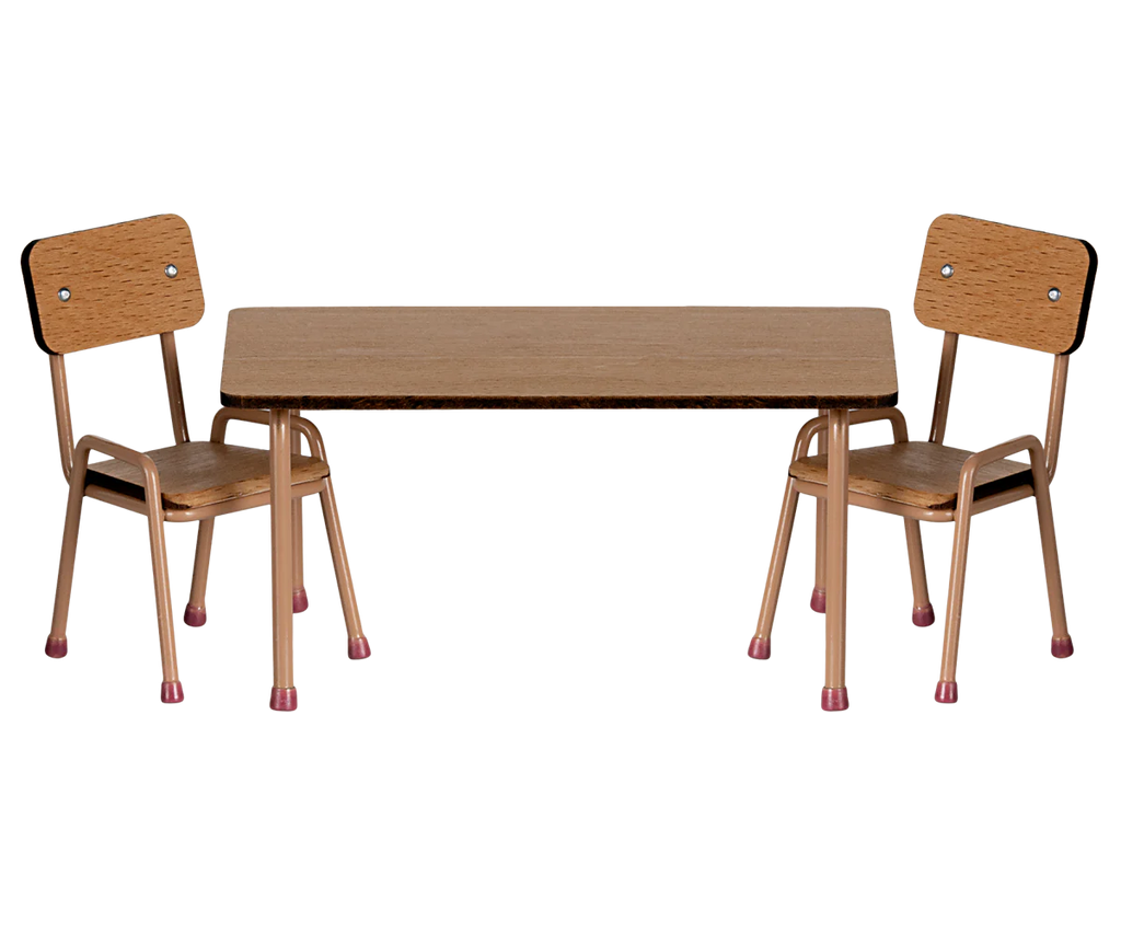 The Maileg School Table & Chair Set for Mice in Dark Powder features two beech wood chairs with metal frames, placed around a rectangular table. Its minimalist design is highlighted by handmade color details and protective pink rubber tips. Ships in approximately one week.