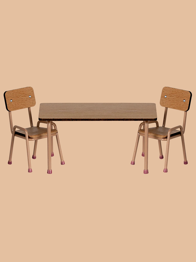 A minimalist image features the Maileg School Table & Chair Set For Mice in Dark Powder, with two beech wood chairs and a rectangular table against a beige background. Handmade accents highlight the light wood seats and backrests, evoking Mouse Hole Farmhouse charm. Ships in one week.